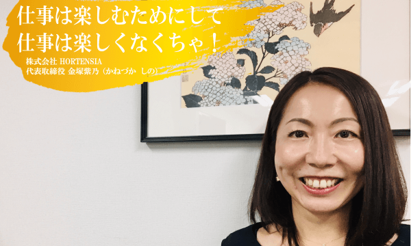 株式会社HORTENSIA代表取締役金塚紫乃さんインタビュー　紫陽花の絵の前で笑顔の女性